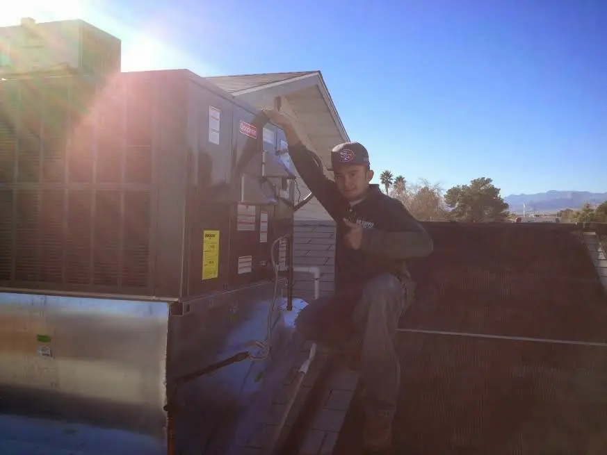 HVAC technician performing AC Tune-Up on a rooftop unit in Erwin